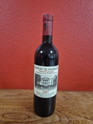 une bouteille de vin rouge posée sur une table en bois