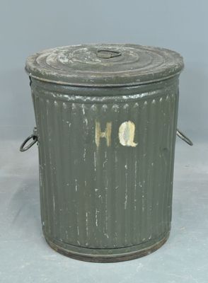 a metal trash can with a lid on a table
