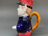 a figurine of a man with a hat and a cane