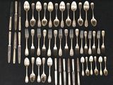 many forks and spoons laid out on the table