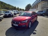 la voiture rouge est garée devant un bâtiment dans un parking