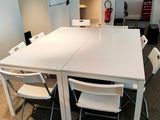 une table blanche avec des chaises et un réfrigérateur blanc en arrière-plan