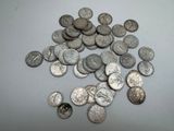 some silver coins are scattered on a white surface