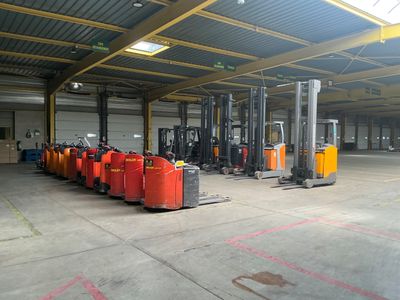 un grand entrepôt où s'entassent de nombreux conteneurs orange au sol