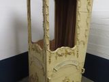 une armoire en bois surmontée d'un baldaquin, placée dans un coin de la pièce