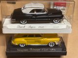 deux petites voitures dans une vitrine posée sur une table