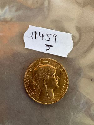 une pièce d'or posée sur une table, avec une étiquette indiquant son prix