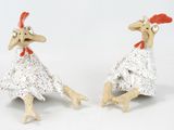 two figurines of a chicken that are sitting next to each other