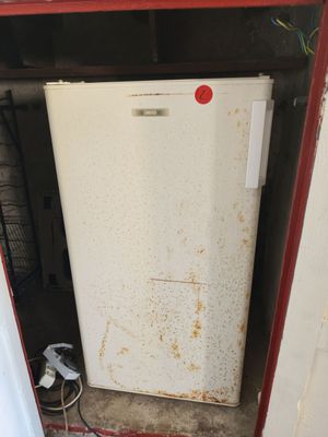 un réfrigérateur blanc posé dans le coin d'une pièce