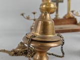 a small brass bell on a table with a chain around it