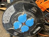 an image of a black hose reel sitting on top of a pile of wires