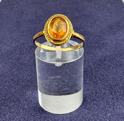 bague plaquée or, ornée d'une citrine au centre, montée sur un verre transparent