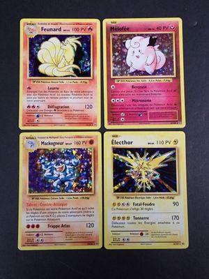 quatre cartes Pokémon aux motifs différents posées sur une table