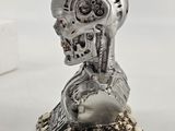skull head sculpture on a rock with skulls and skulls around it