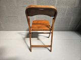 a wooden chair that is sitting in front of a wall