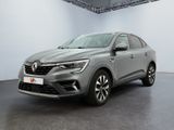 Une voiture grise est garée dans une pièce aux murs blancs.