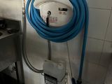 un tuyau bleu fixé au mur dans les toilettes publiques