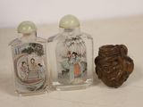 three glass bottles with asian designs on them on a table