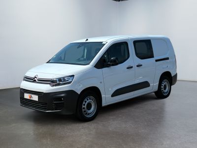 La camionnette blanche est garée dans une grande pièce blanche.