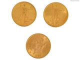 trois pièces d'or sont représentées sur une surface blanche
