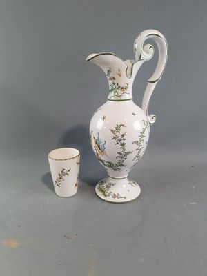a white vase and a cup sitting on a table