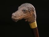 a close up of a wooden stick with a horse head on it