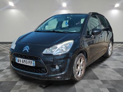 la voiture noire est garée sur un sol en damier dans le garage