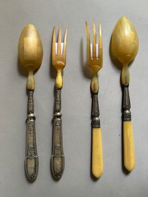 quatre cuillères et une fourchette sont alignées sur une table