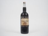 une vieille bouteille de vin posée sur une surface blanche