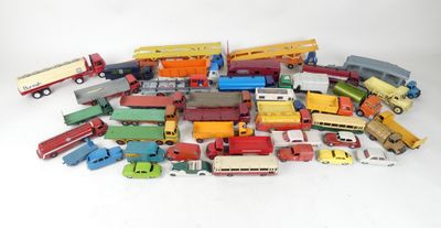 a pile of toy cars and trucks on a white surface