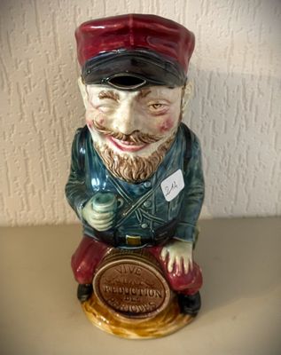 une figurine en céramique représentant un homme assis sur une table