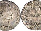 a silver coin with a woman ' s head and laurels on it