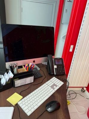 a desk with a computer, keyboard, mouse, and other items on it