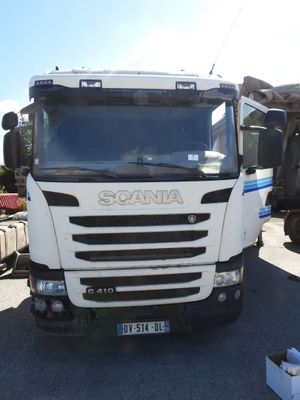 un camion garé sur un terrain avec d'autres camions à l'arrière-plan
