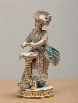 a figurine of a woman sitting on a table