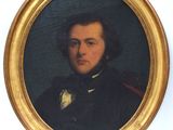 portrait of a man in a black coat and bow tie in a gold frame