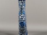a blue and white vase sitting on a gray surface