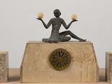 a statue of a woman sitting on top of a clock
