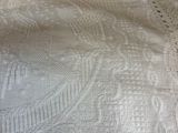 a close up of a bed with a white bedspread