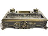an image of a black and gold writing desk with a pen and inkwell