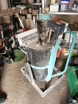 a machine that is sitting in a garage next to a pile of trash
