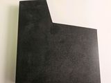 a close up of a piece of black paper on a white surface