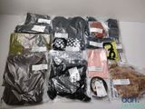de nombreux types de vêtements différents, rangés dans des sacs posés sur la table