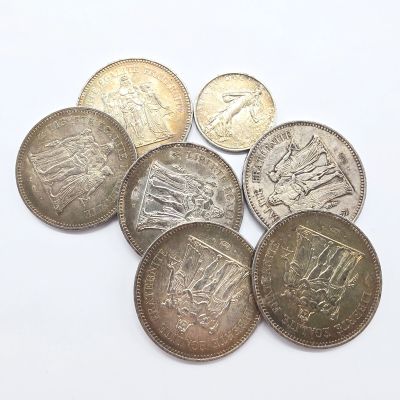 six pièces de monnaie britanniques différentes empilées les unes sur les autres sur une surface blanche