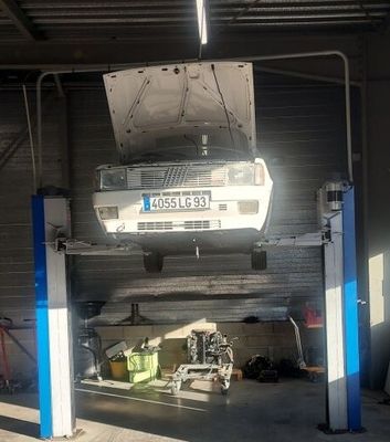 une voiture posée sur un pont élévateur dans un garage