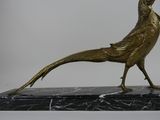 statue of a golden pheasant on a black marble base