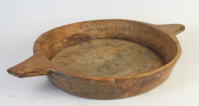 a wooden bowl with a handle on a white surface