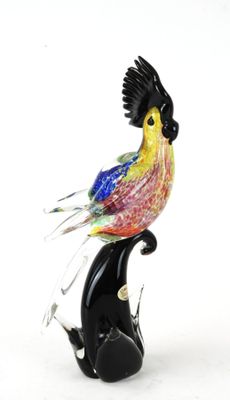 un oiseau en verre coloré perché sur le dos d'un chat noir