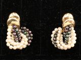 deux paires de boucles d'oreilles en perles et en or exposées dans une vitrine