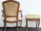 two chairs and a stool in a room with a white wall